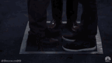a blurry picture of three men standing in a room with the hashtag # brooklyn99 on the bottom