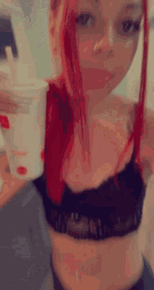 a woman with red hair is sitting on the floor in a kitchen while a man holds her arm .