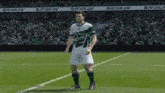 a soccer player is standing on a soccer field .