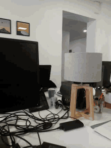 a computer monitor sits on a messy desk next to a bottle of coca cola