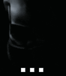 a black and white photo of a woman 's torso in the dark