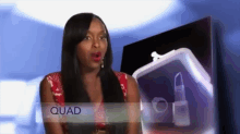 a woman is standing in front of a purse with the word quad on it