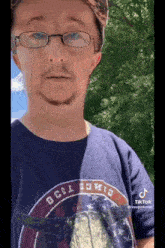 a man with glasses and a beard is wearing a blue t-shirt that says beer bowie