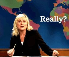 a woman is sitting at a desk with a pen in her hand in front of a map that says really on it