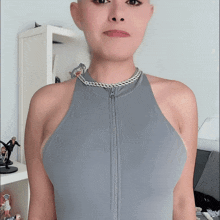a woman in a grey tank top with a zipper on the front