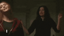 two women are dancing in a dark room and the words `` i will be your '' are visible .