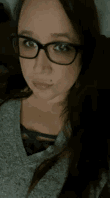 a woman wearing glasses making a funny face with her tongue out