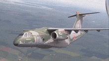a military plane is flying in the sky and has the letters coca on the side