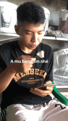 a young man wearing a black shirt that says milkbeki