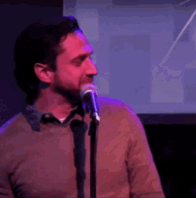 a man singing into a microphone with a blue background