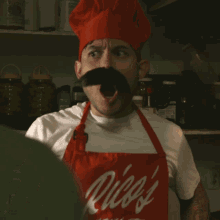 a man wearing a chef 's hat and an apron that says rizzi