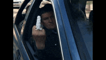 a man in a car with a bandage on his finger is giving the middle finger