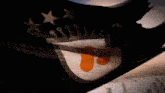 a black flag with a white and orange circle with the letter t on it