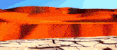 a desert landscape with a blue sky and a cracked ground in the foreground