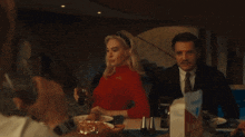 a woman in a red sweater is sitting at a table with a man