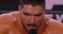 a close up of a man 's face with a microphone in front of him .