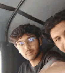 two young men are taking a selfie together in a car .