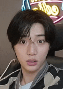 a close up of a young man 's face with a surprised look on his face .