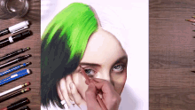 a person is drawing a woman 's face with green hair on a wooden table .