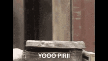 a black and white photo of a trash can with the words `` yooo piri '' on it .