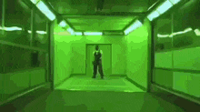 a man in overalls is standing in a room with green lights