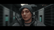 a man wearing a black jacket and a black beanie