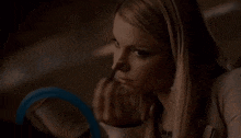a woman looks at herself in a mirror while holding a bottle