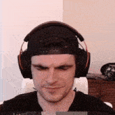 a man wearing headphones and a hat is making a face .
