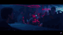 a crowd of people are dancing in a dark room in a club .