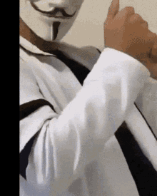 a man wearing a white shirt and tie is wearing a mask
