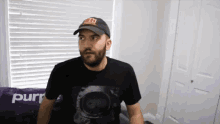 a man wearing a hat and a t-shirt that says purr on it