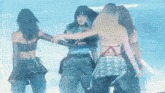 a group of women are dancing on a stage with a blue background