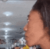 a close up of a person 's face with a sign in the background that says ' a ' on it .