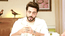 a man is sitting at a table looking at his phone