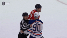 a hockey player with the number 90 on his jersey talks to a referee