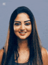 a woman with long hair is smiling and wearing a heart shaped necklace