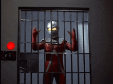 a man in a superhero costume is standing in a room with a red light on the wall