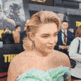 a woman in a green dress is standing in front of a sign that says " the "