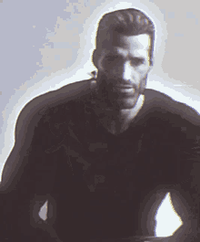 a man with a beard is wearing a black shirt and looking at the camera