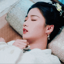 a woman with a flower in her hair is sleeping on a bed