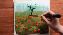 a person is using a spatula to spread paint on a painting of a tree
