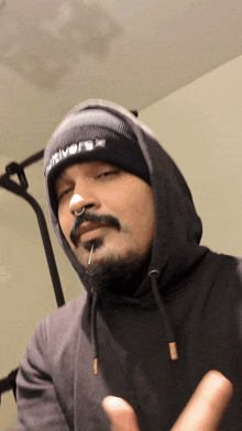 a man wearing a hoodie and a beanie with the word river written on it