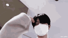 a man wearing a white face mask is being photographed by dspn gallery