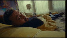 a man with a beard is laying on a bed with his eyes closed