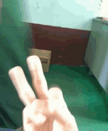 a person is giving a peace sign in front of a cardboard box