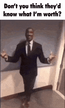 a man in a suit and tie is standing in a hallway with his hands outstretched .