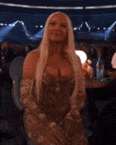 a woman in a very revealing dress is sitting in a crowd at a concert .