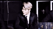a man in a suit and tie is dancing on a stage .