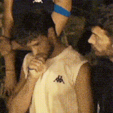 a man wearing a kappa shirt holds a microphone in his hand