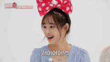 a girl wearing a headband with mickey mouse ears is smiling and says 하이어어어